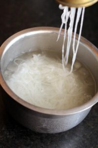 making faloodeh noodles by colander